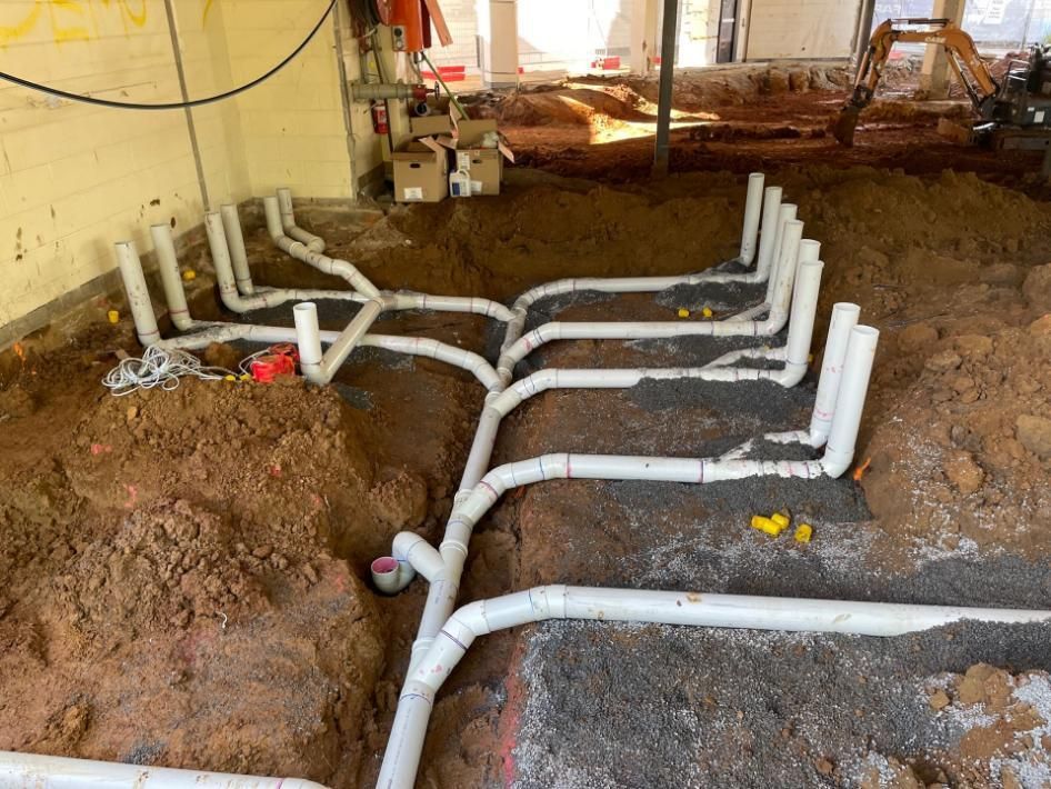 Bunch of Pipes Are Laying in the Dirt in a Room — Beards Roofing and Plumbing in Clontarf, QLD