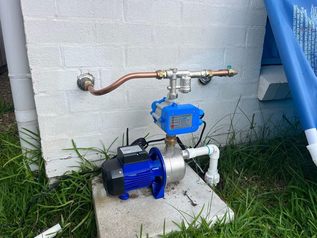 Blue Water Pump is Attached to a Brick Wall — Beards Roofing and Plumbing in Clontarf, QLD