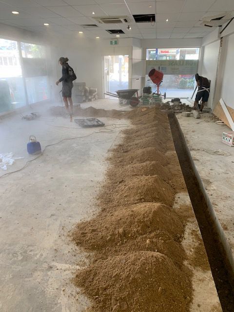 A Man is Standing in a Room With a Lot of Dirt on the Floor — Beards Roofing and Plumbing in Kallangur, QLD