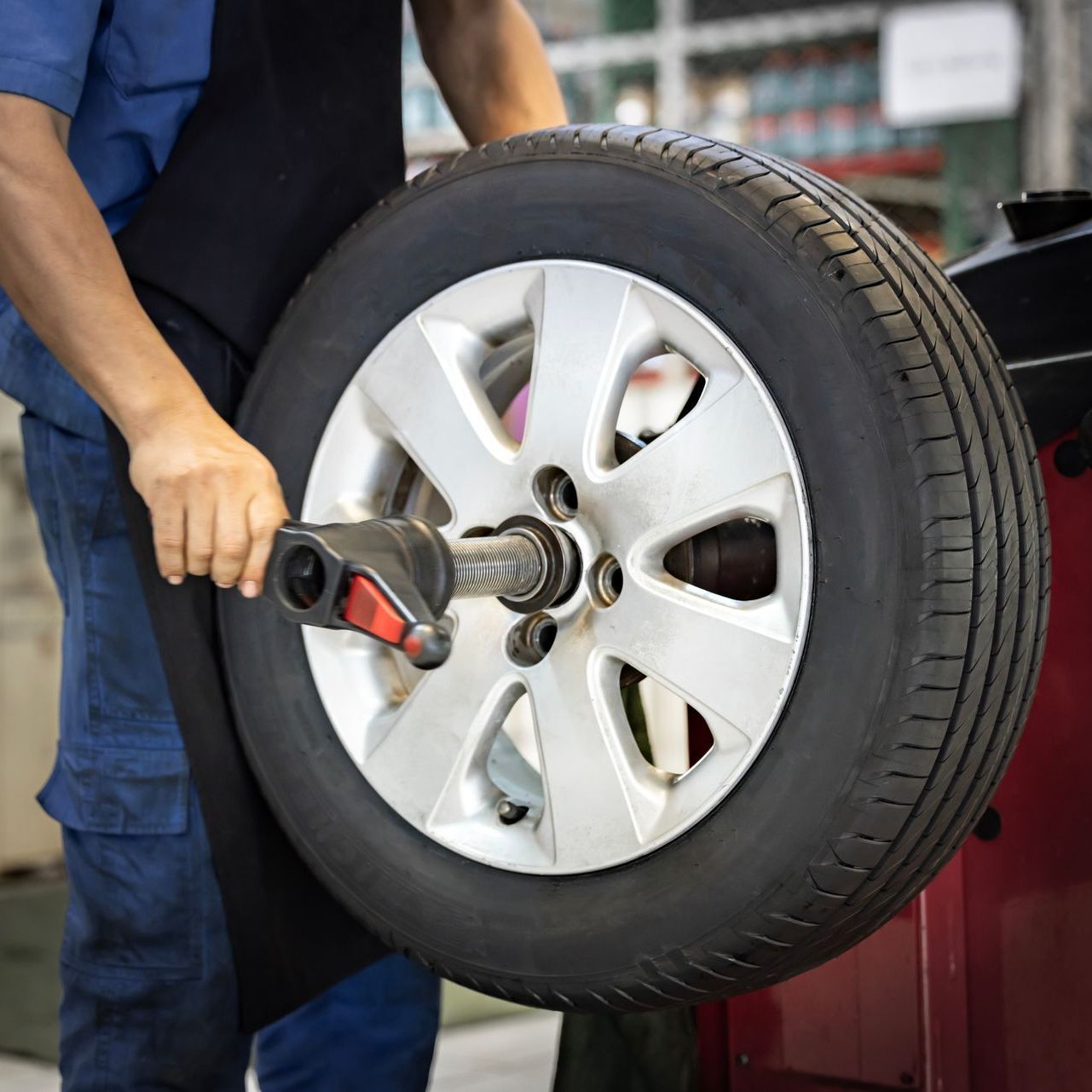 A man is balancing a tire on a machine.