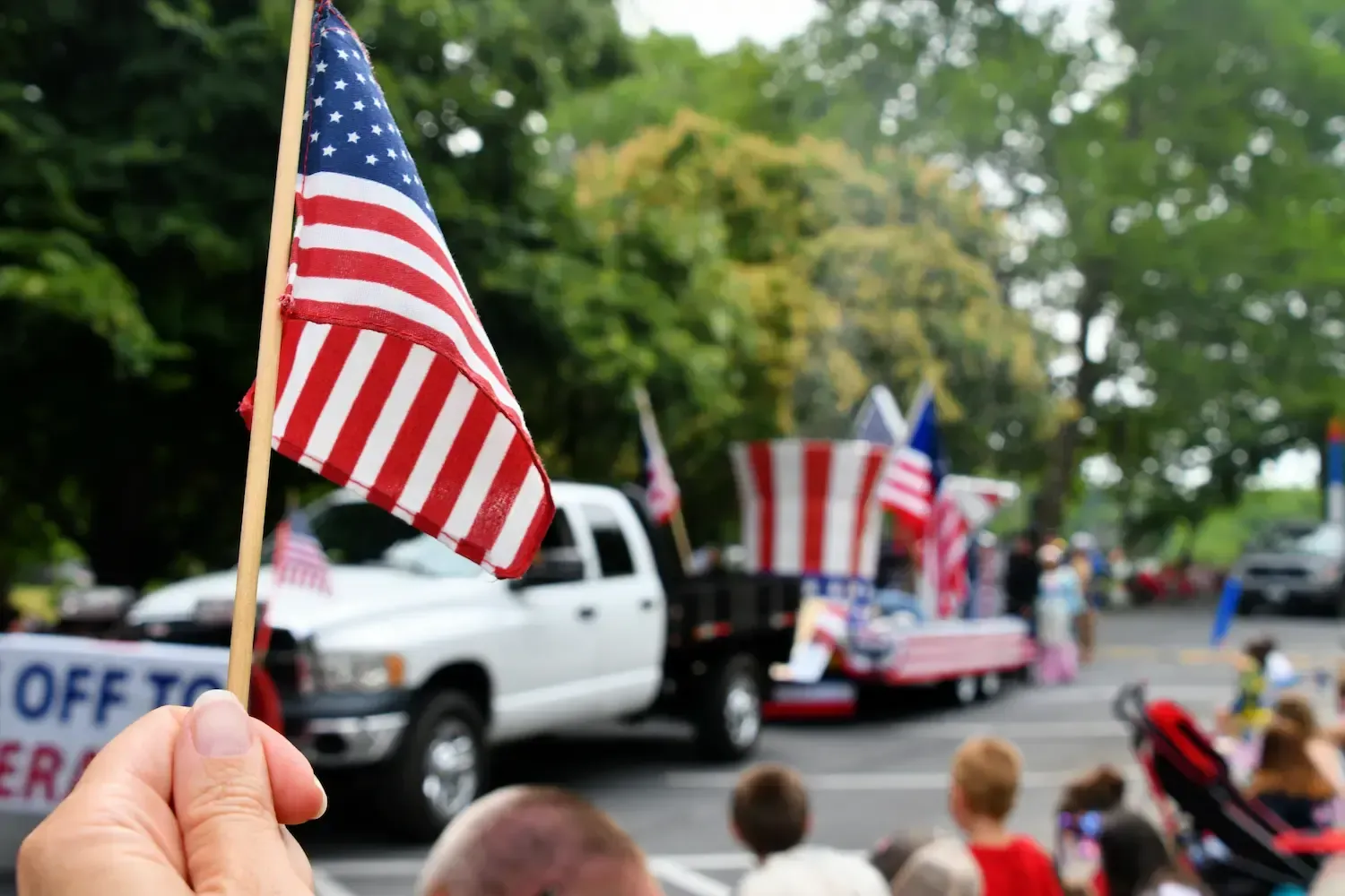 Hand waving an american USA flag while watching a parade