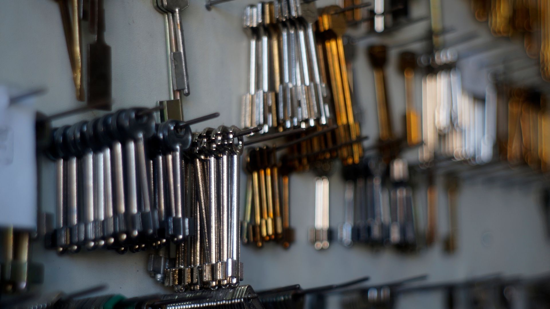 A bunch of tools are hanging on a wall.