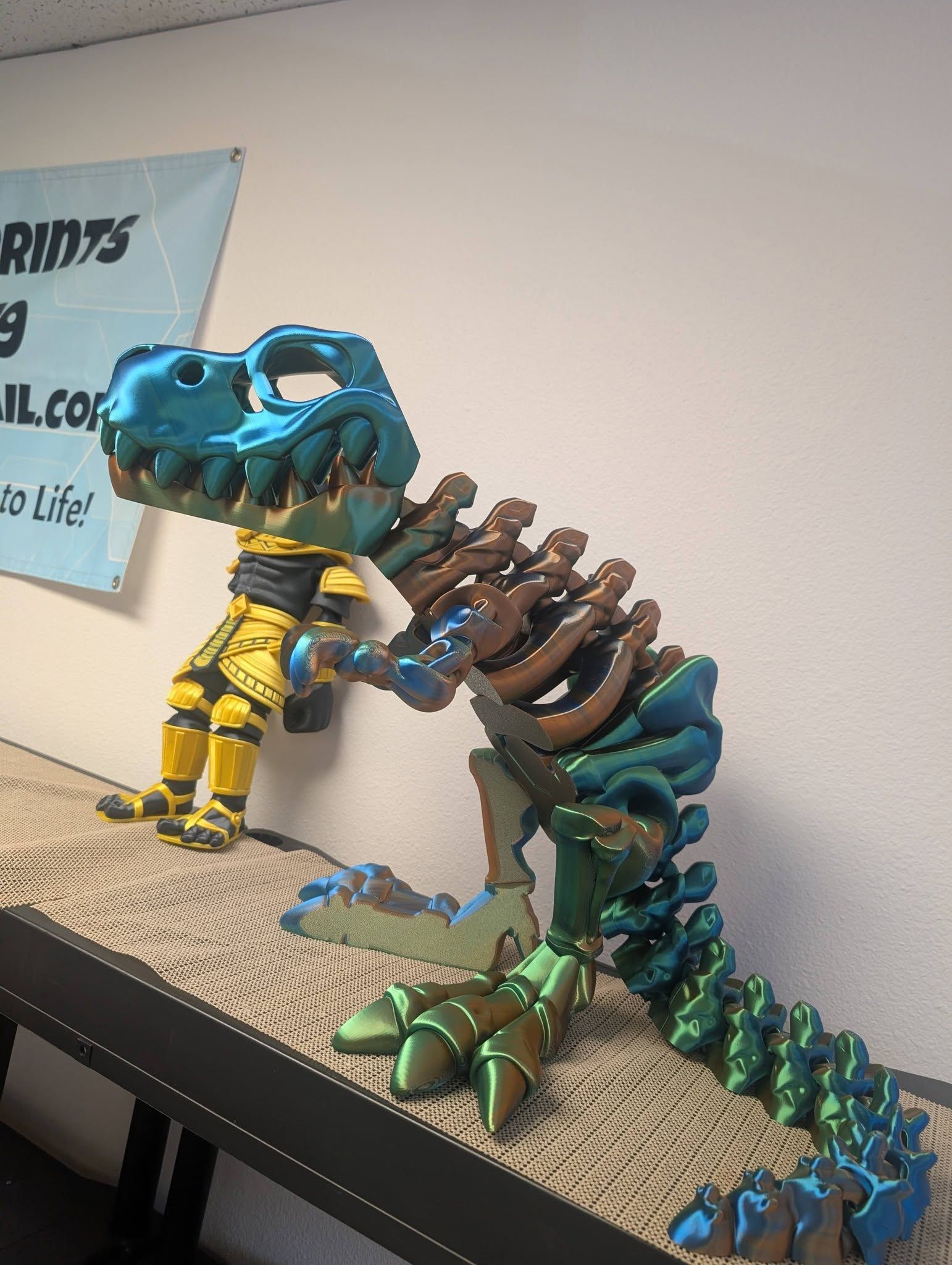 Blue and teal dinosaur skeleton figurine with exposed ribs on a shelf against a wall