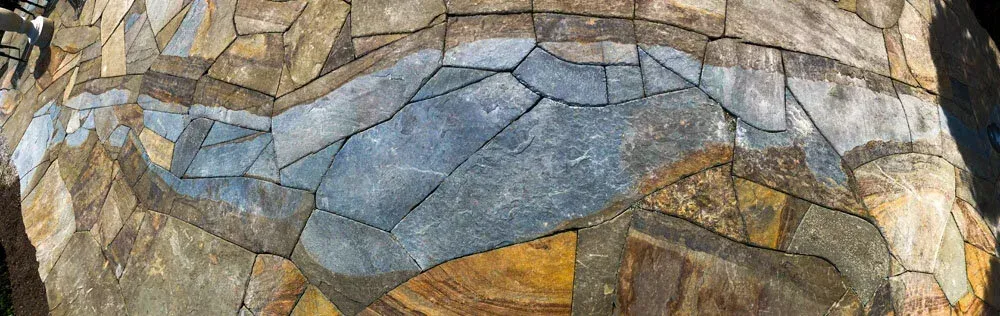 Close-up of a multicolored stone mosaic with blue, gray, and tan pieces