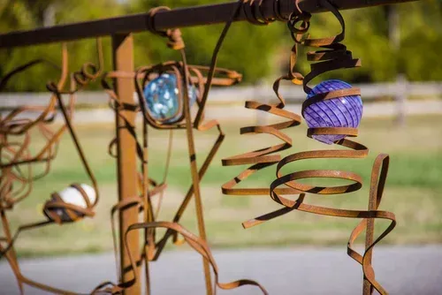 Two hanging blue and purple lanterns with spiral wire decorations outdoors