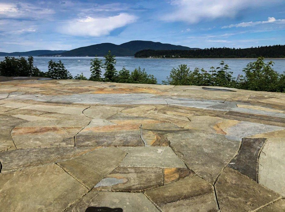 Natural stone hardscape patio overlooking the water on Whidbey Island, WA, by Creative Gardens.