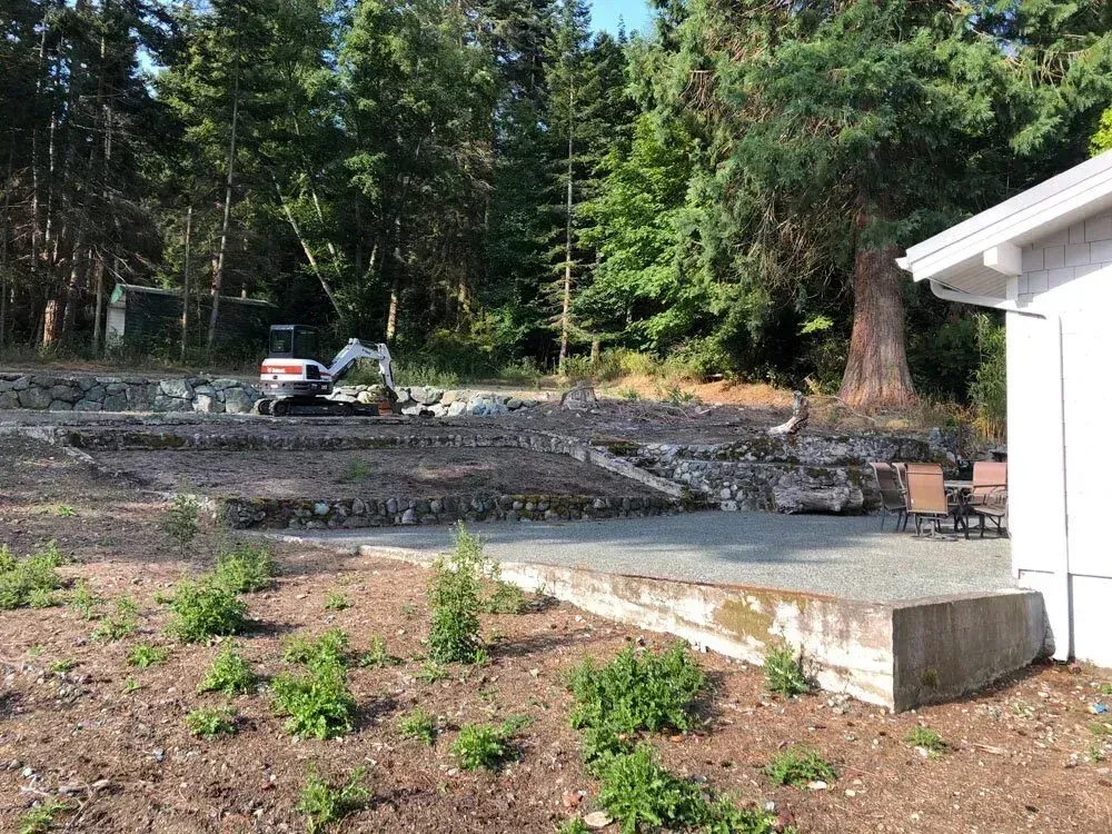 Waterfront summer home site with a stone retaining wall before regrading