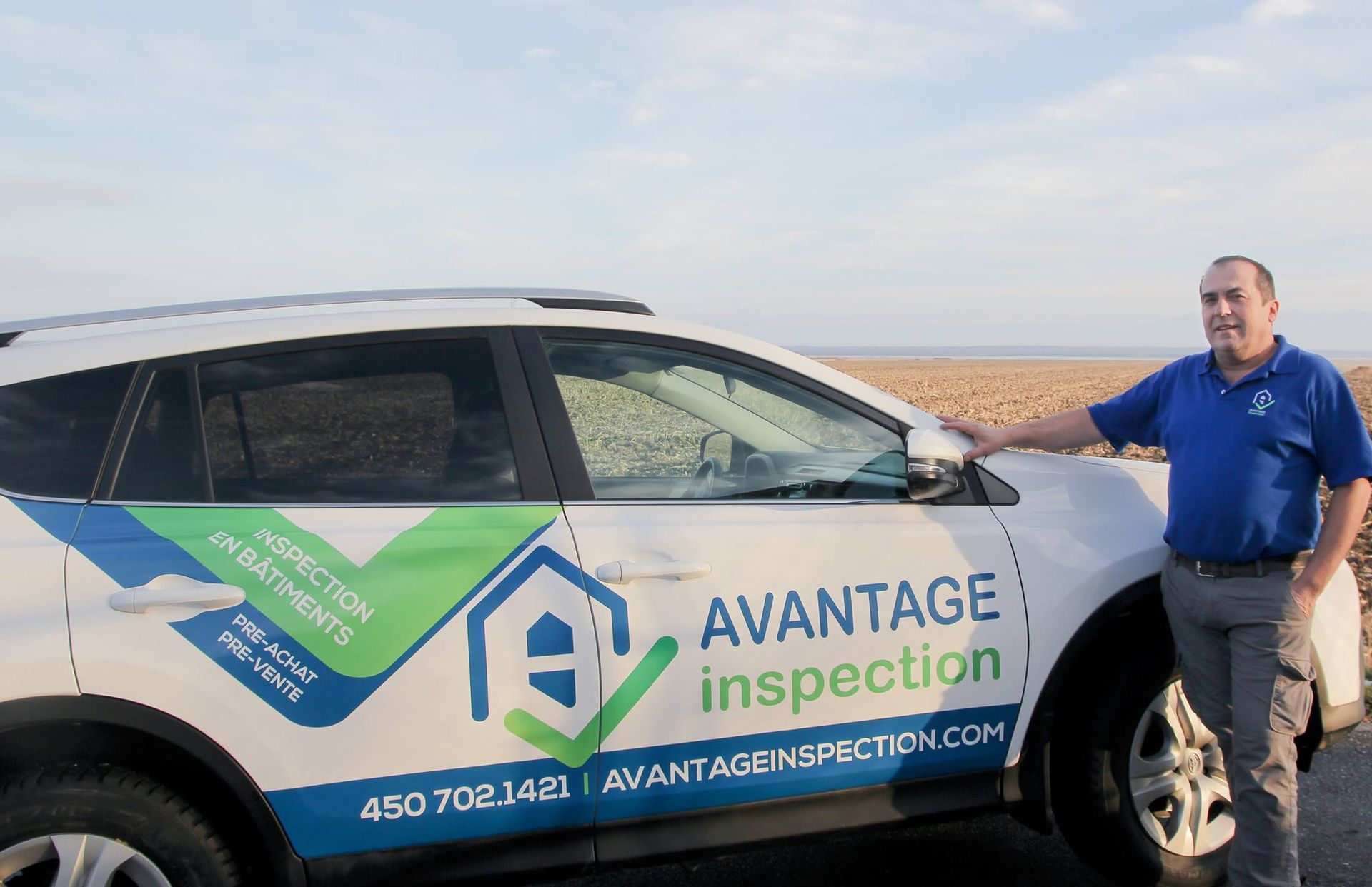 Un homme se tient à côté d'une voiture d'inspection Vantage