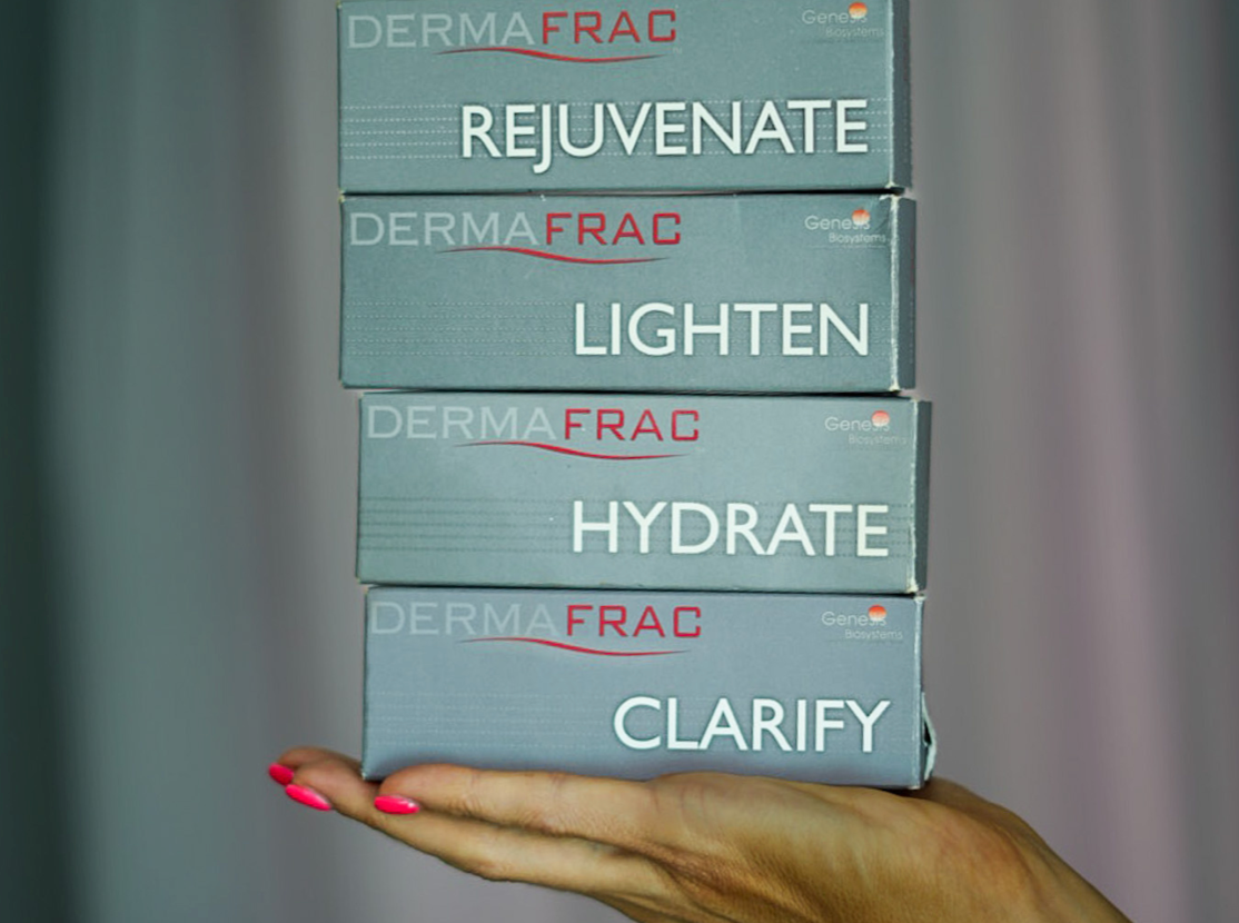 Hand holding four Dermafrac skincare boxes labeled Rejuvenate, Lighten, Hydrate, and Clarify