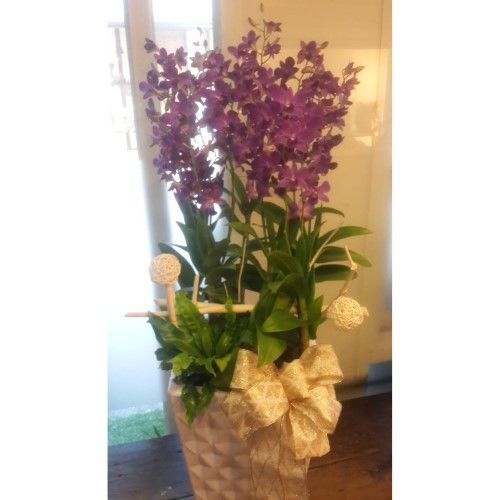 裝飾花瓶中插著紫色蘭花，花瓶上繫著蝴蝶結，點綴著綠葉和小裝飾球。