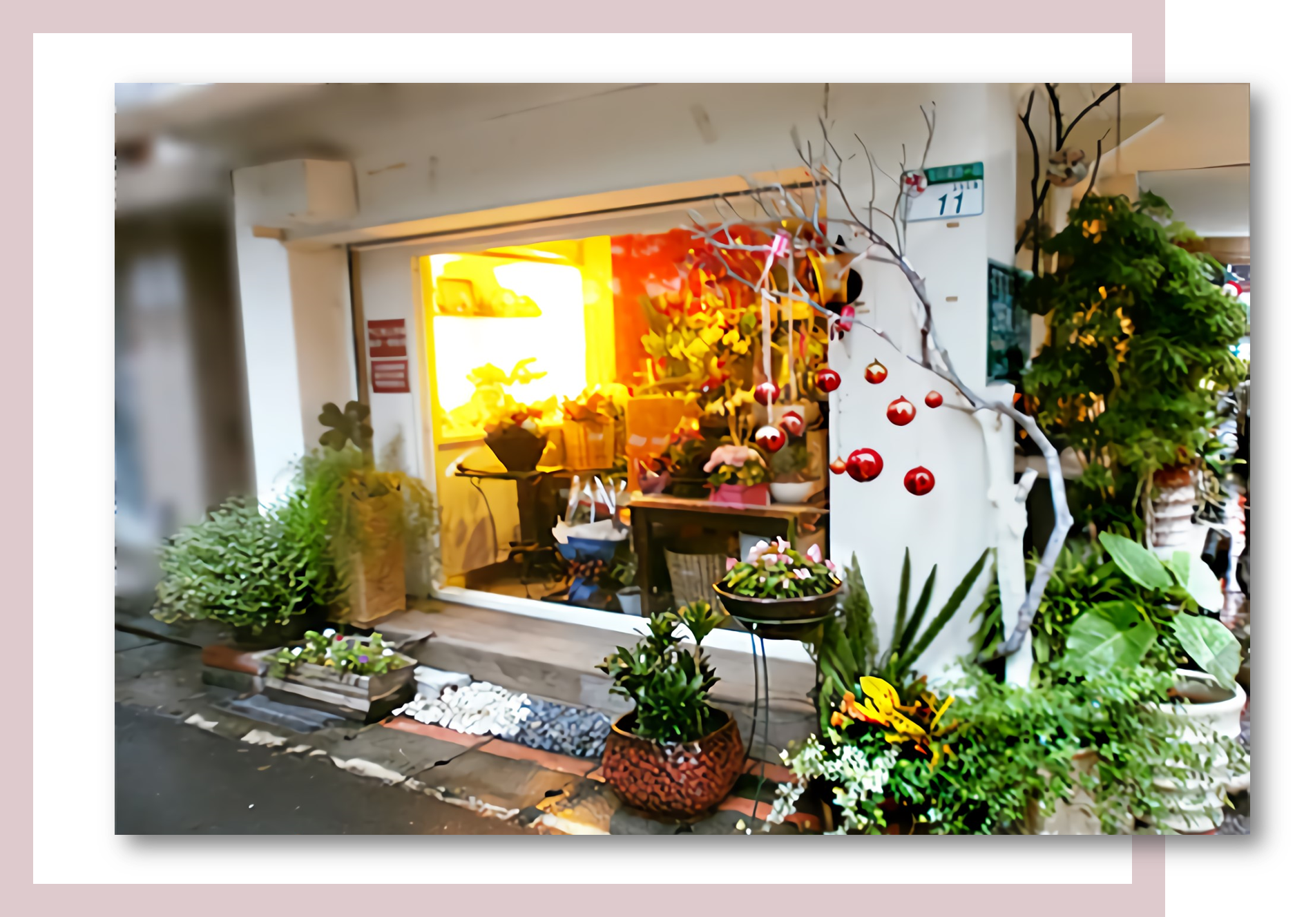 花店外觀，花朵盛開，綠植環繞，裝飾喜氣洋洋。店內燈火通明，清晰可見。