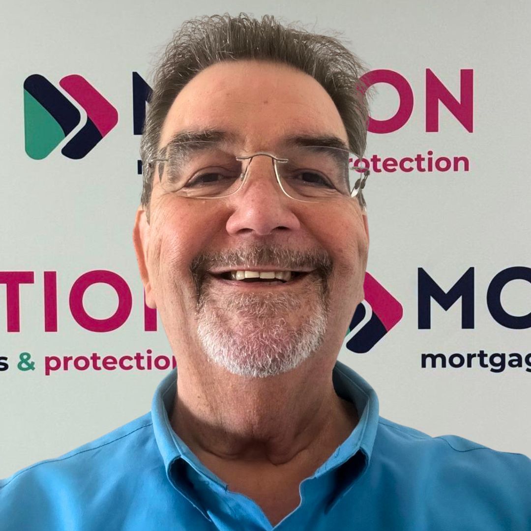 Alan Sherville of Motion Mortgages & Protection is smiling in front of a branded backdrop