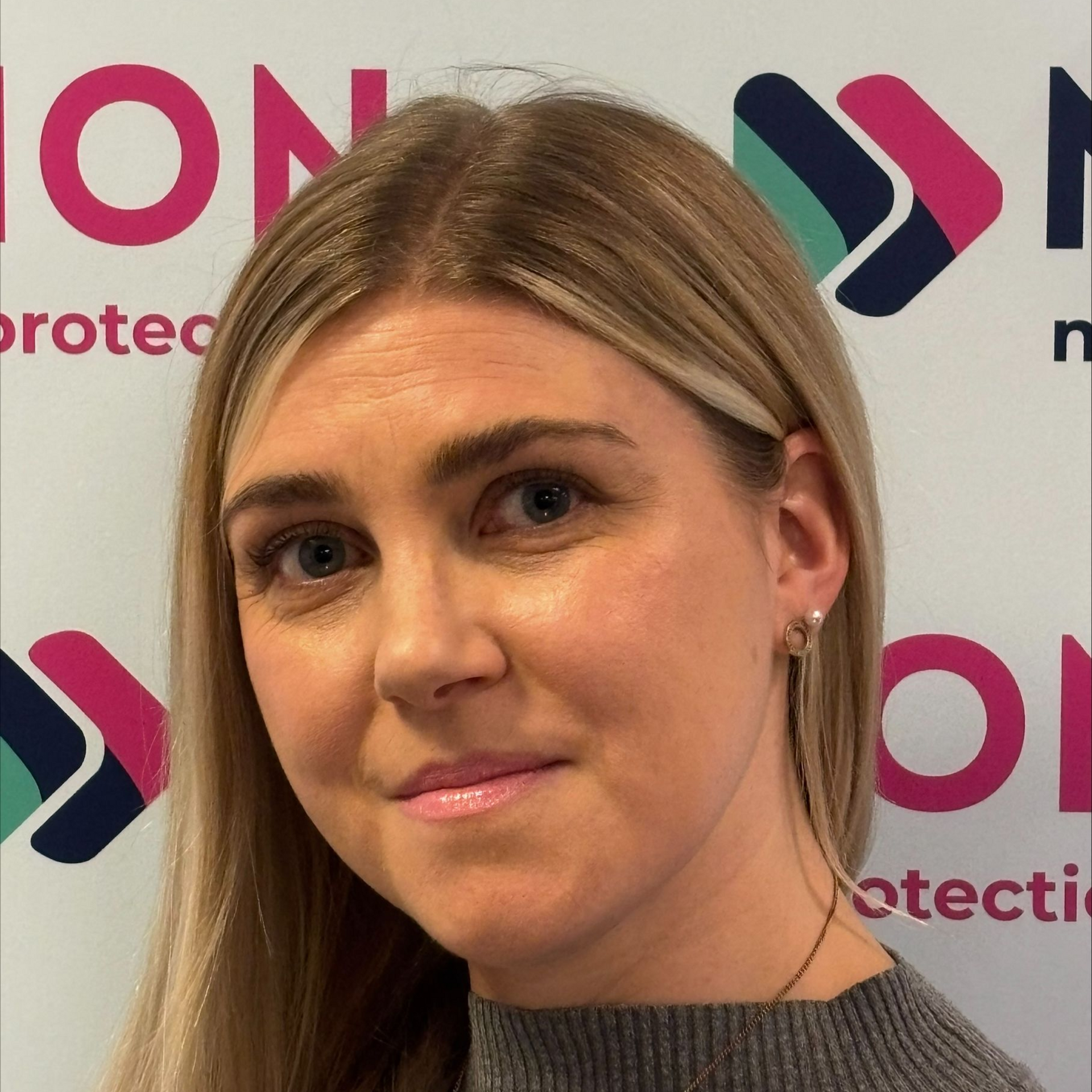 Matt Penfold of Motion Mortgages & Protection is smiling in front of a branded backdrop