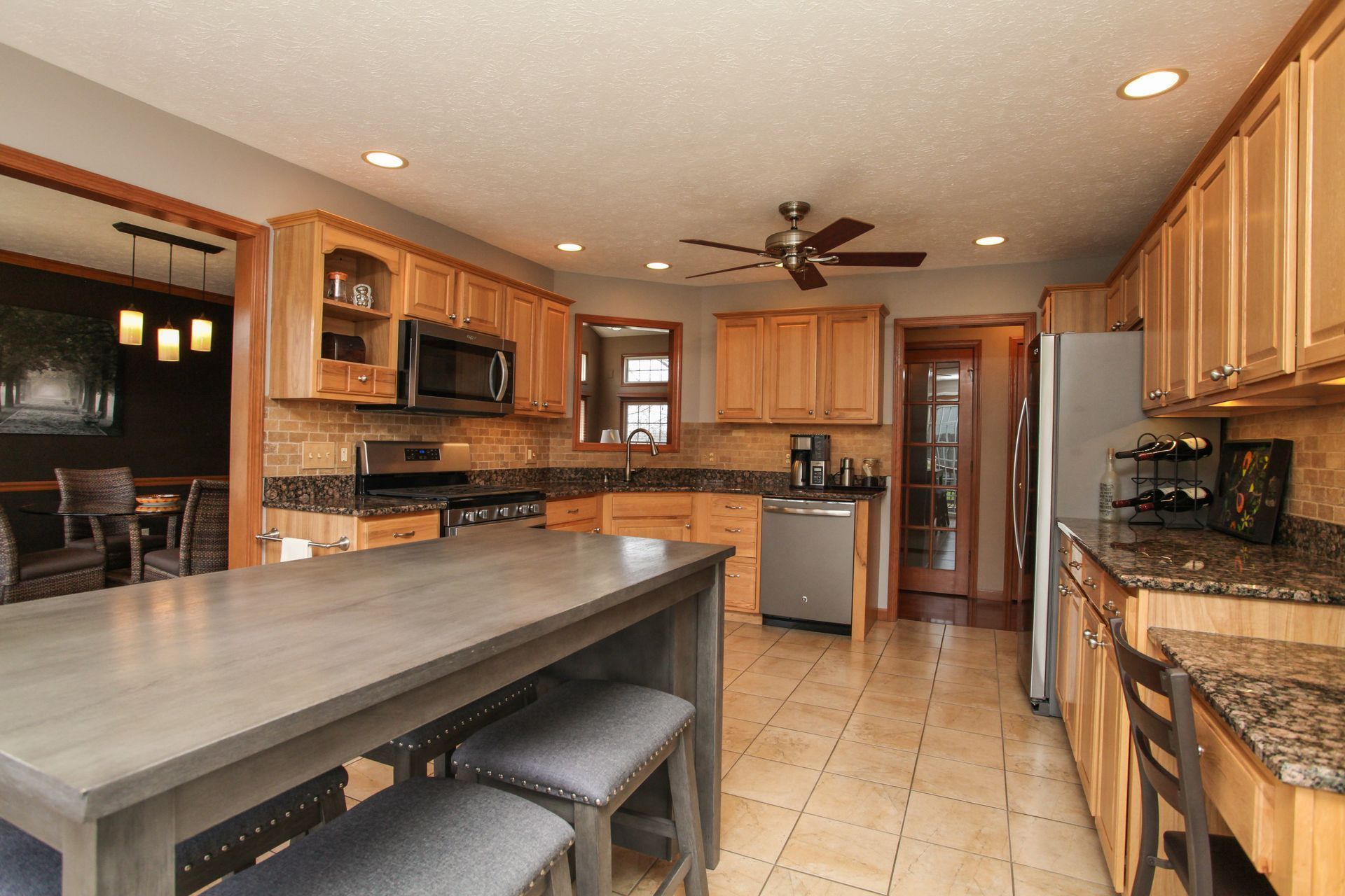 Spacious kitchen with wood cabinets, granite counters, center island, and stainless steel appliances.