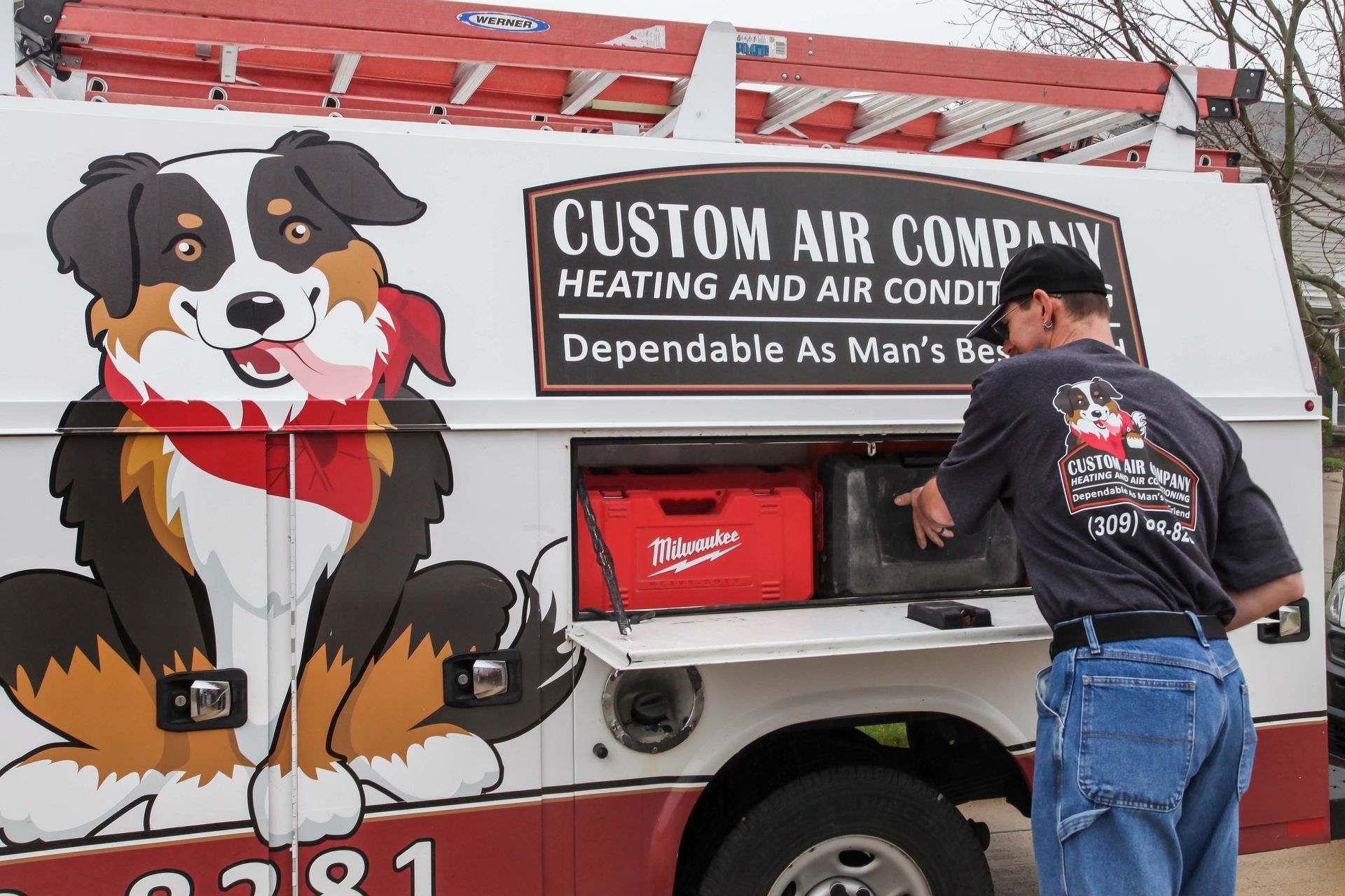 Custom Air Company service truck with a large dog mural and a man loading gear into a side compartment