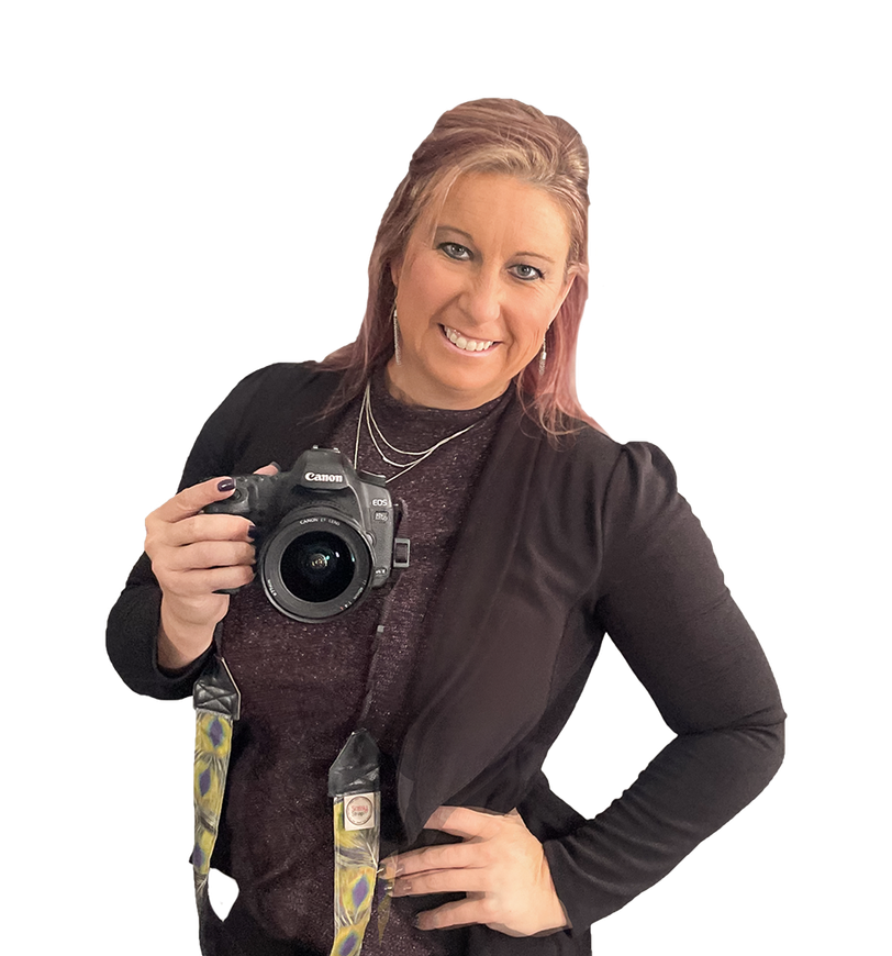 Woman holding a DSLR camera, smiling against a white background.