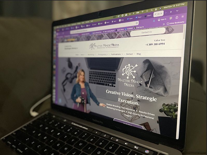Laptop displaying a purple-themed website homepage with a woman and “Creative Vision Strategies” banner