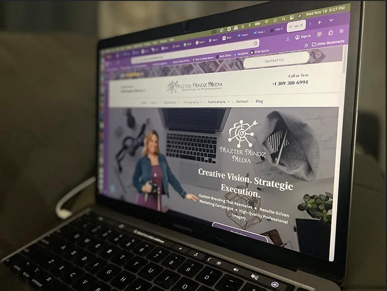 Laptop displaying a website with a purple browser and a banner for “Creative … Strategies”