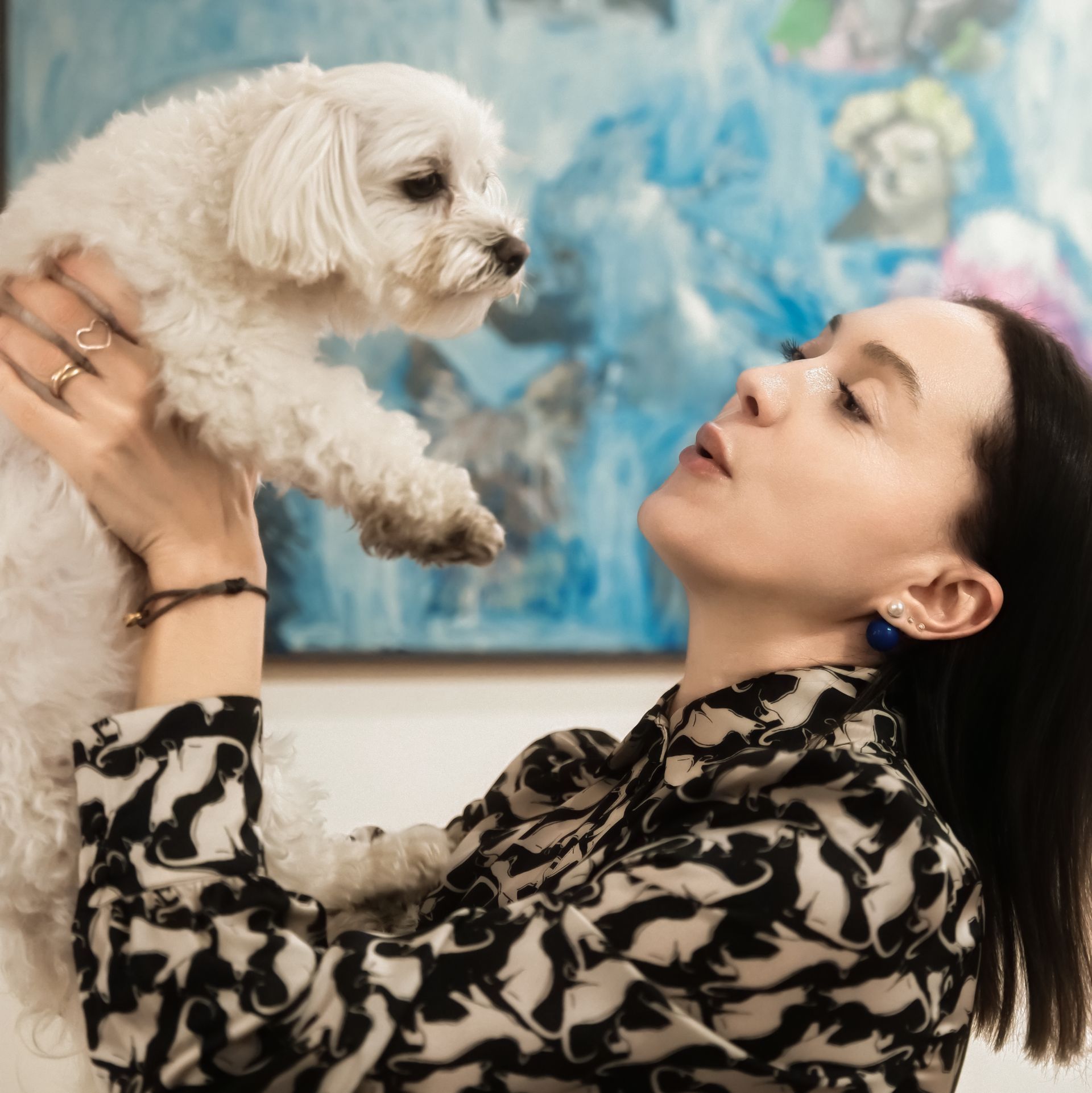 Eine Frau hält einen kleinen weißen Hund im Arm