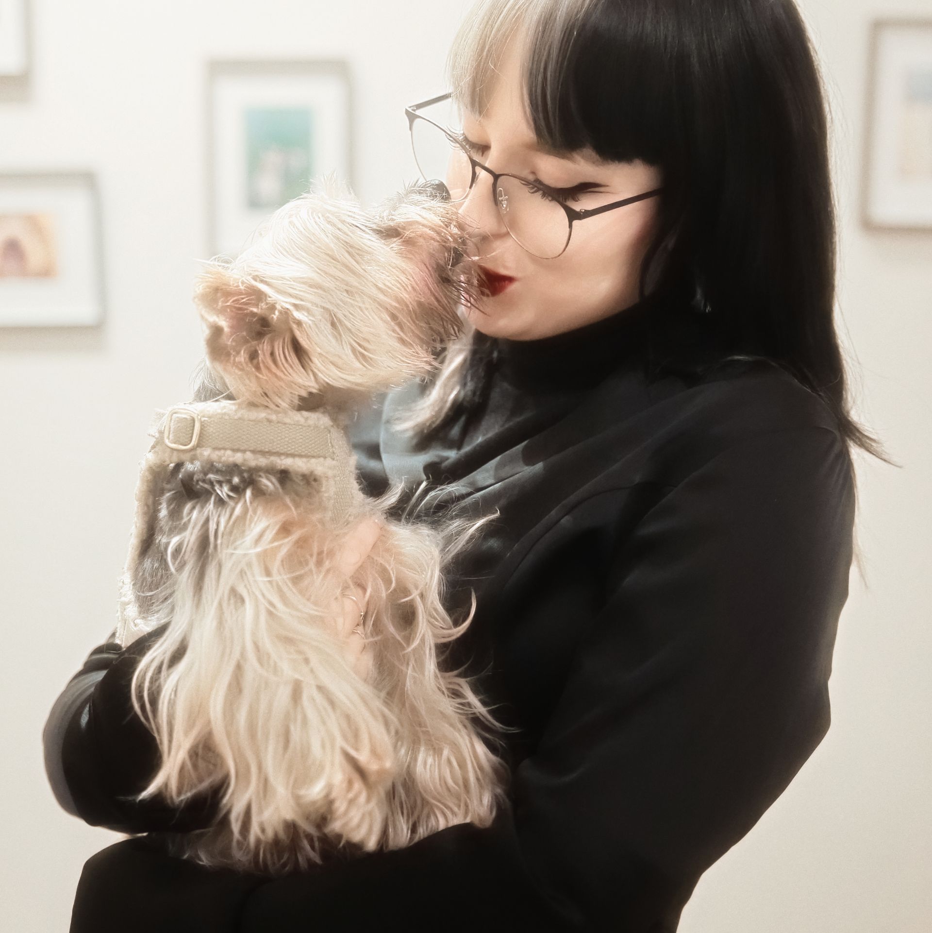 Eine Frau mit Brille hält einen kleinen Hund
