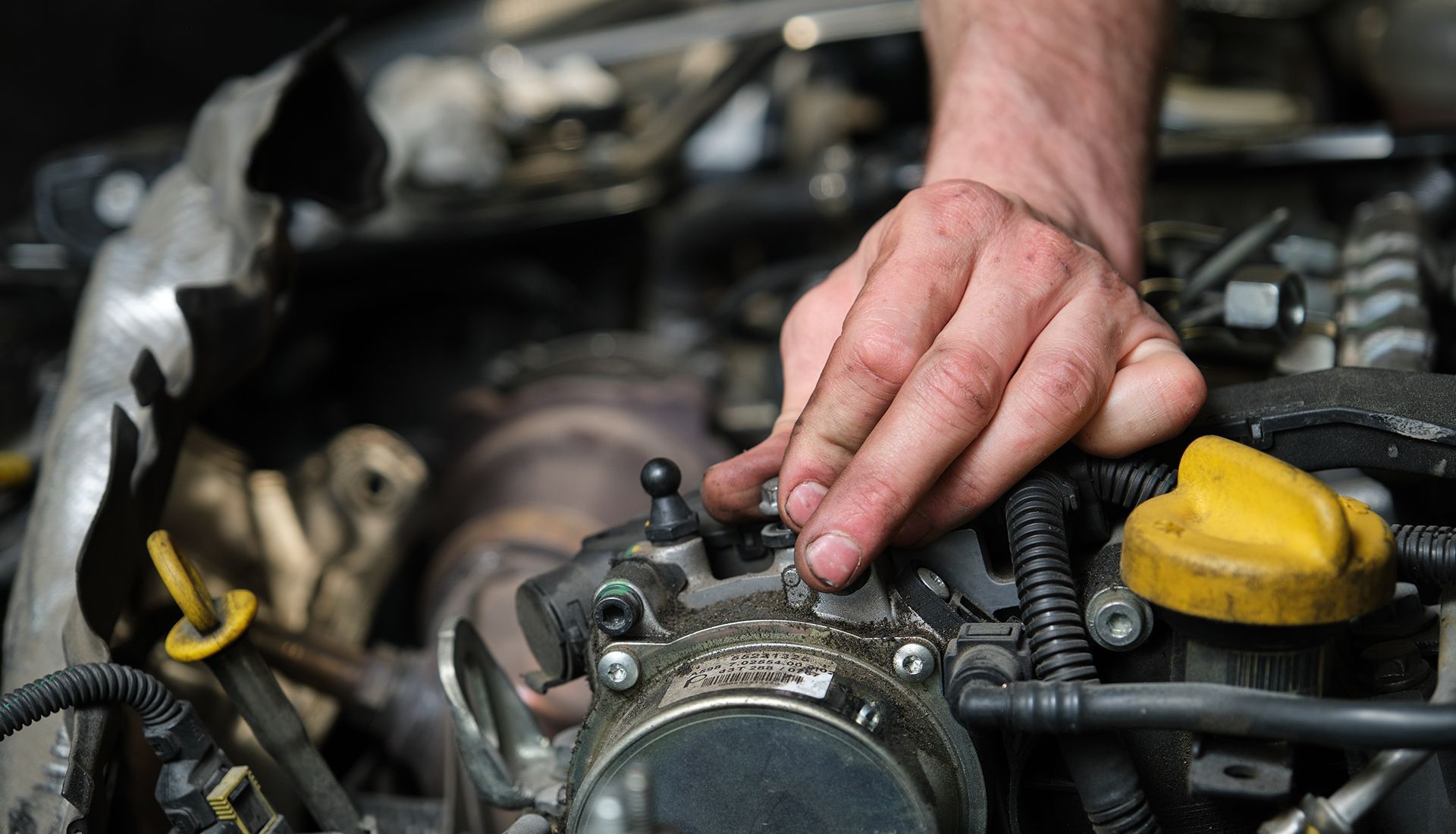 Hand on an engine, working on car repair.