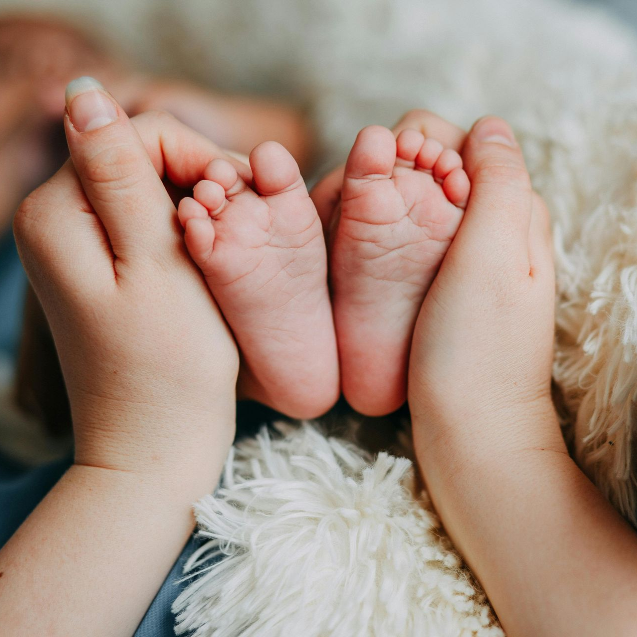 mother holding baby feet
