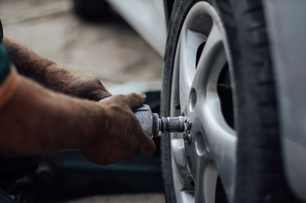 Mechanic tightening a lug nut on a car wheel with a wrench