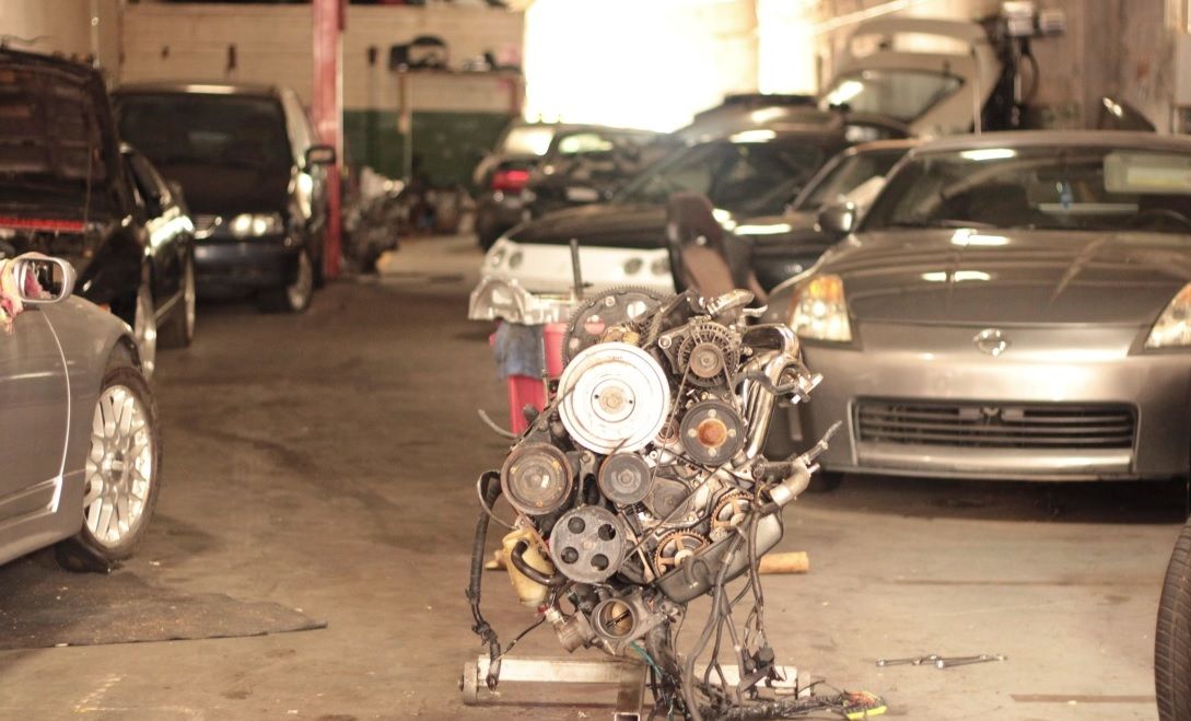 Engine on a cart in a dim parking garage between parked cars