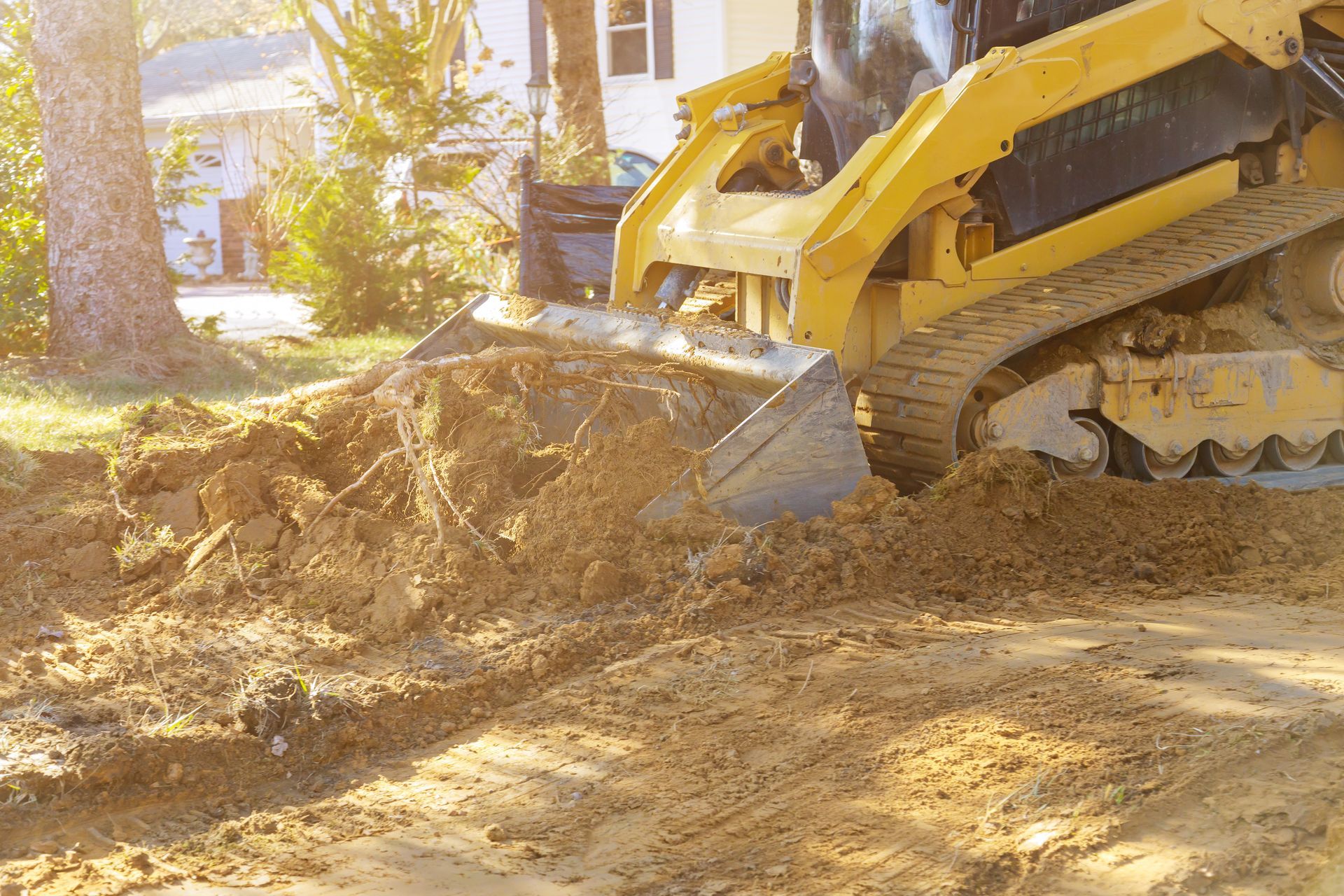 Yellow bulldozer pushing dirt at a construction site in bright sunlight