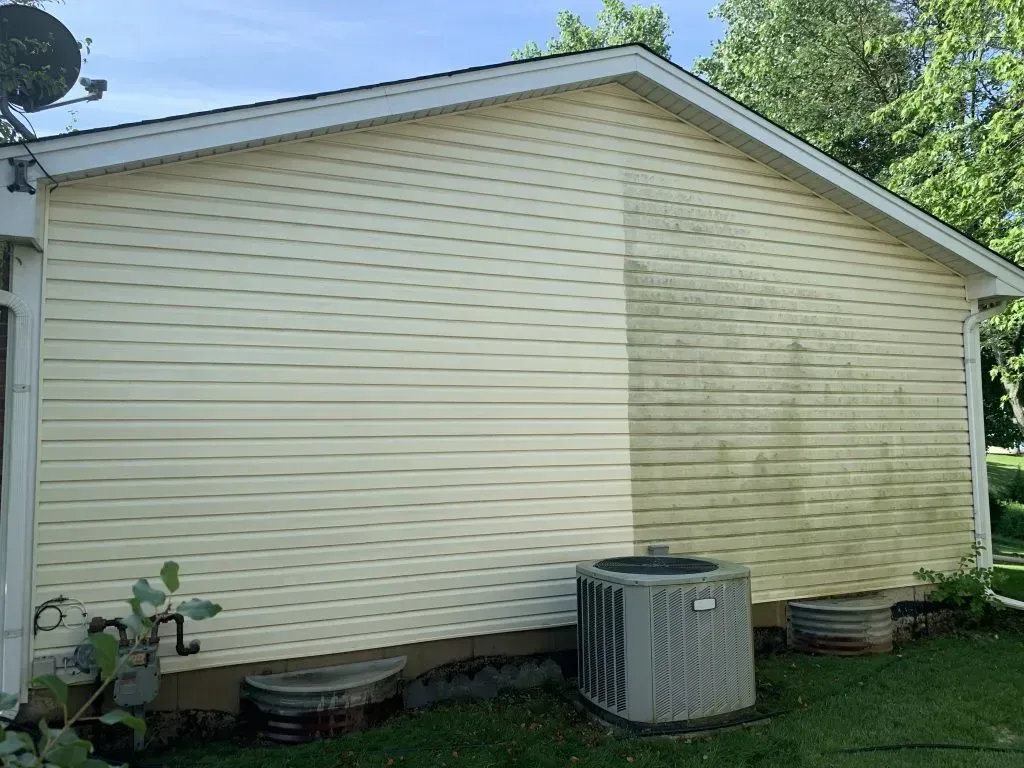 A house with a air conditioner on the side of it.