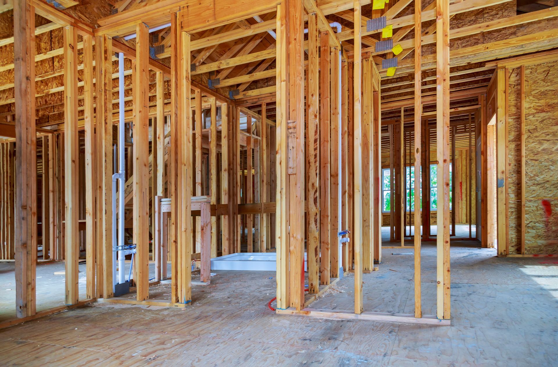 A man is kneeling on the floor working on an electrical outlet.
