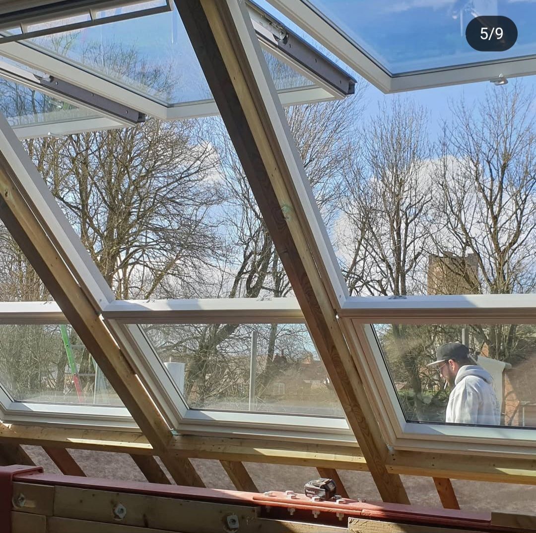 A man is looking out of a window with trees in the background.