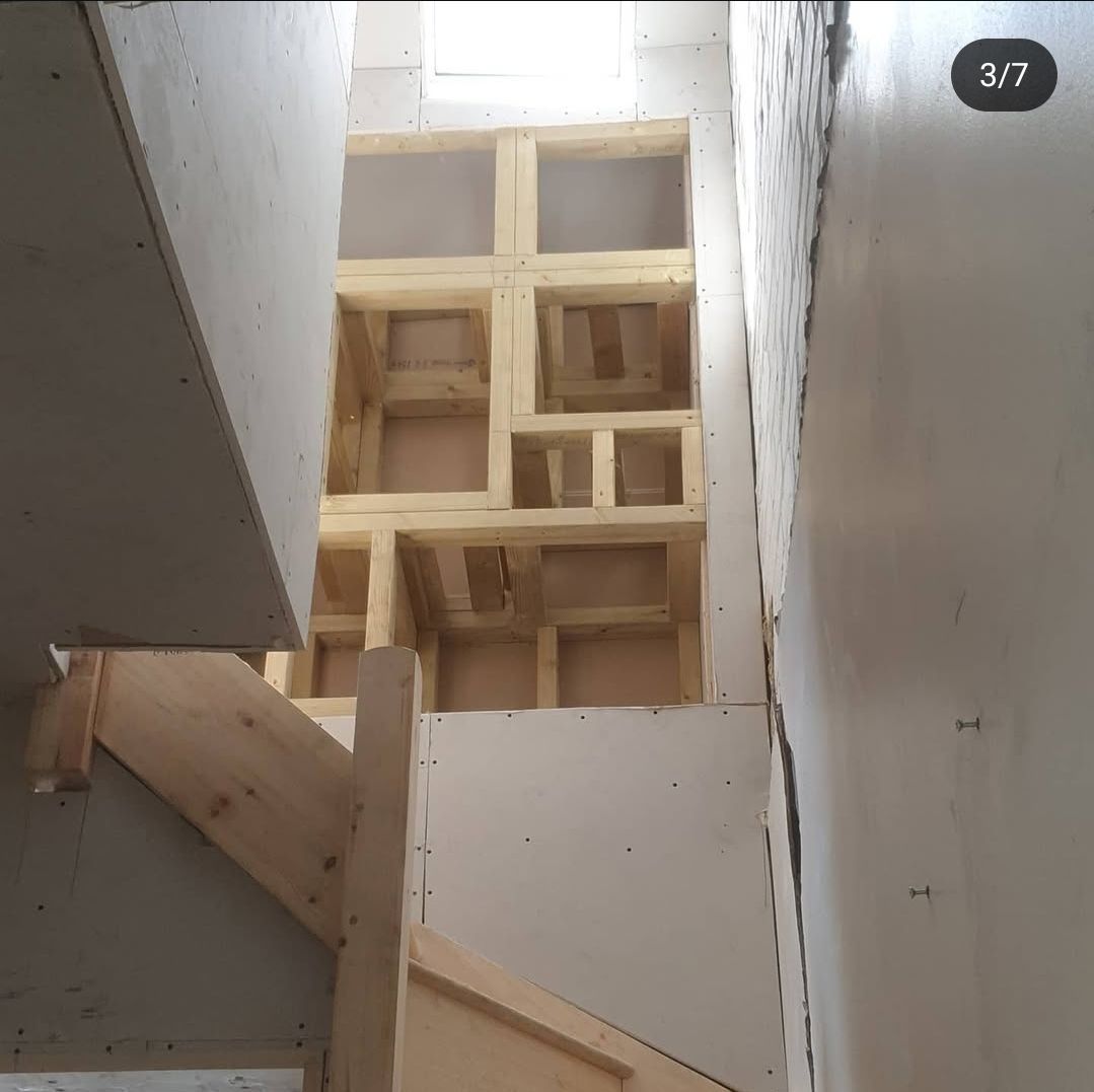 A wooden staircase is being built in a building.