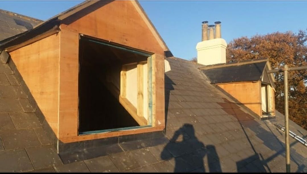 A shadow of a person is cast on the roof of a building