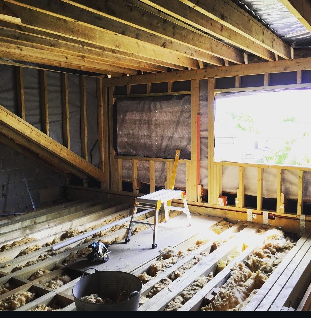 A room under construction with a window and a ladder