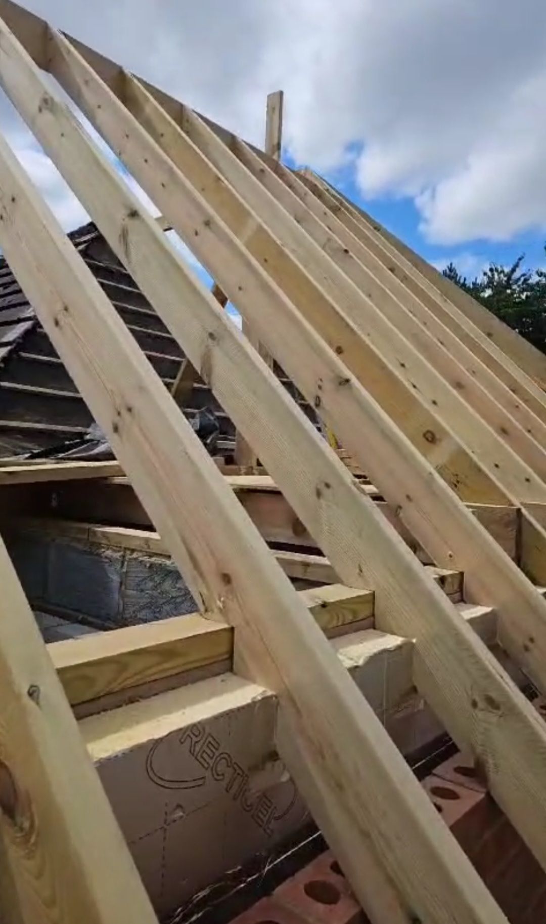 A roof is being built with wooden beams.