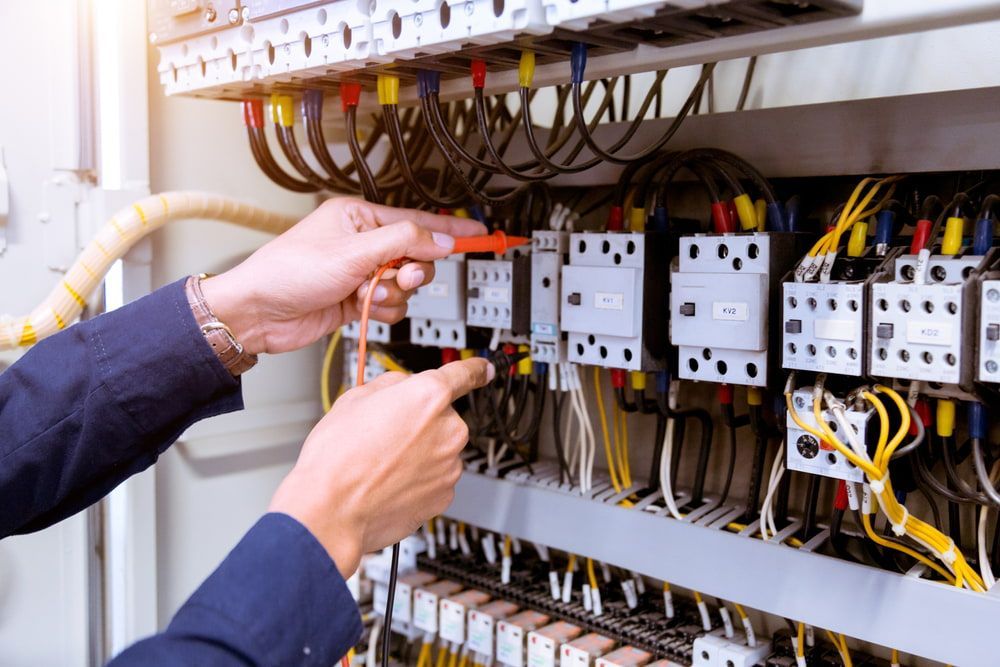 A man is working on an electrical panel with a screwdriver. — KARM Electrical Services In East Maitland, NSW