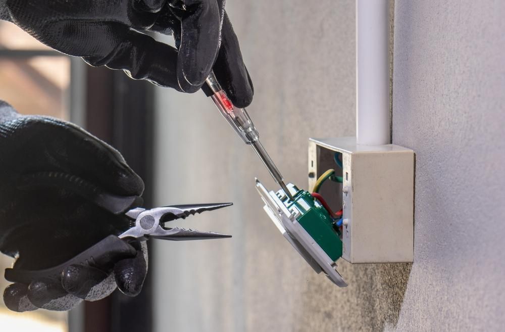 A Person Is Holding a Pair of Pliers and A Screwdriver — KARM Electrical Services In Karuah, NSW