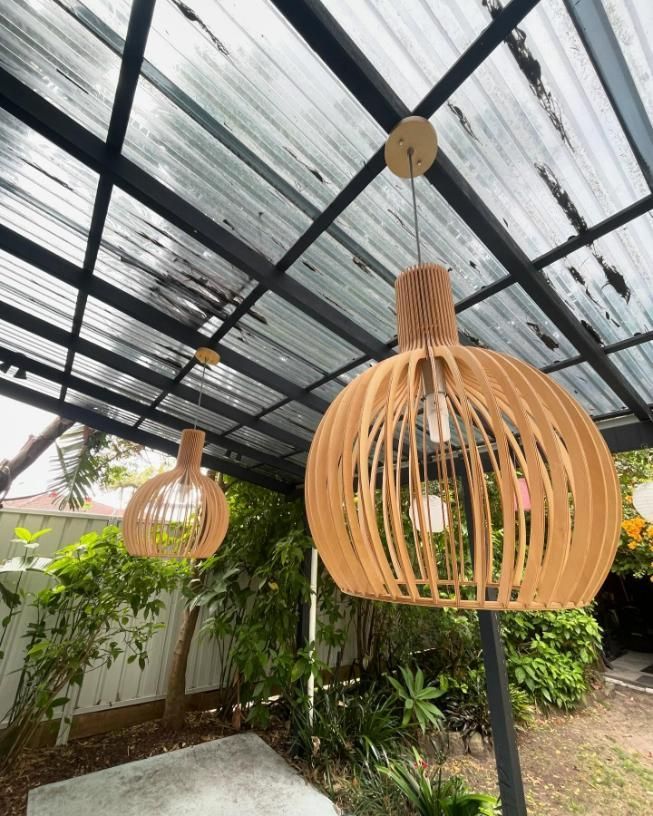 Two Wooden Pendant Lights Are Hanging from A Metal Roof — KARM Electrical Services In Maitland, NSW