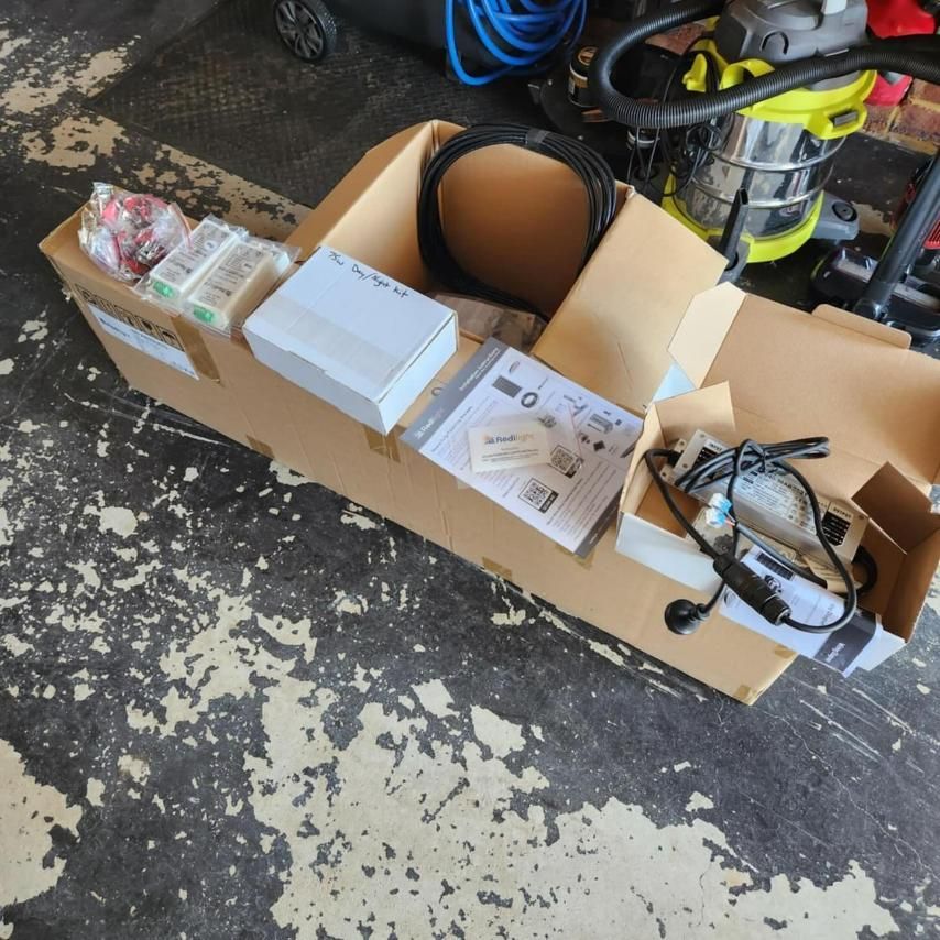 A Cardboard Box Filled with Various Items Including a Vacuum Cleaner — KARM Electrical Services In Karuah, NSW