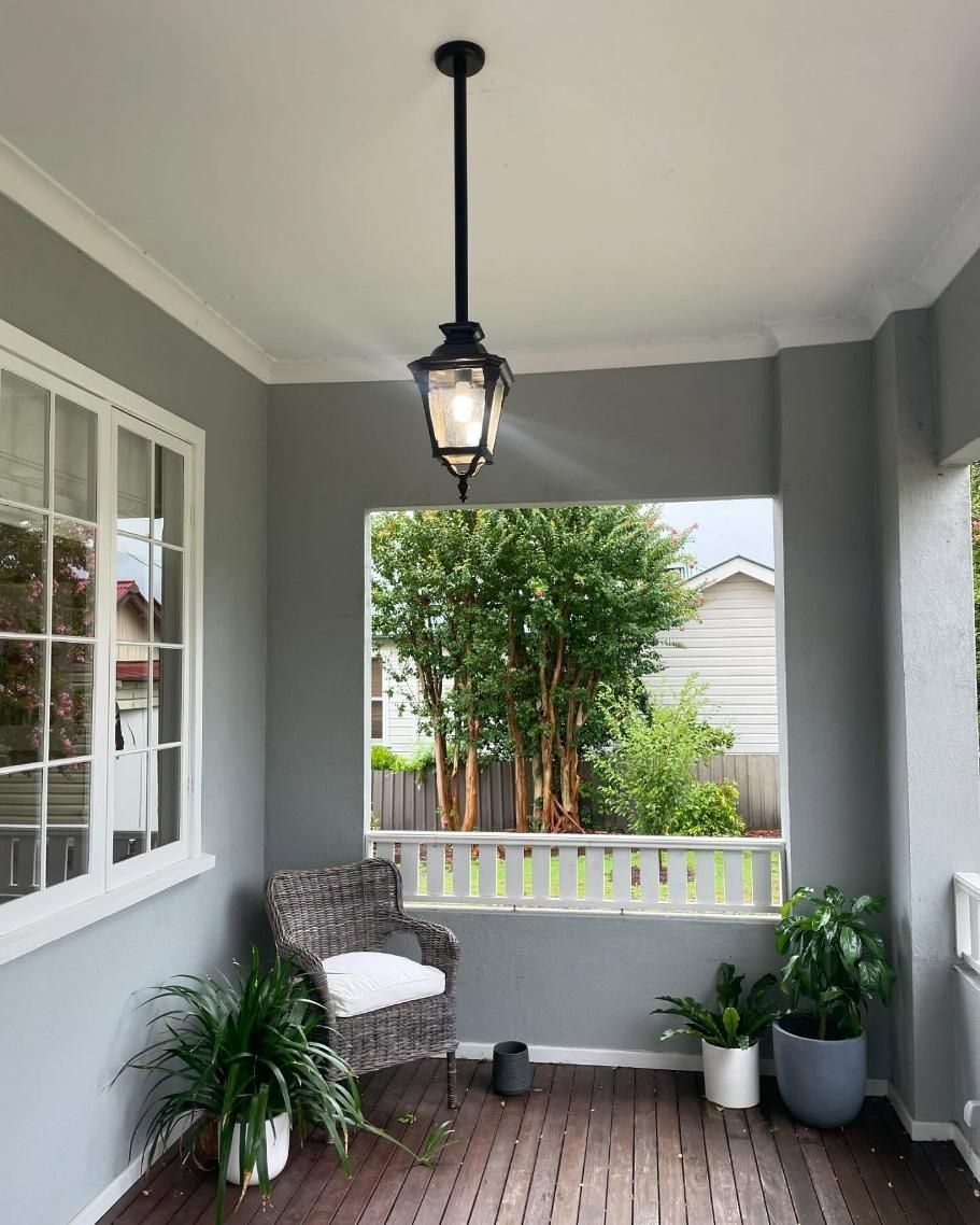 A Porch with A Chair, Potted Plants and A Lantern Hanging from The Ceiling — KARM Electrical Services In Chisholm, NSW