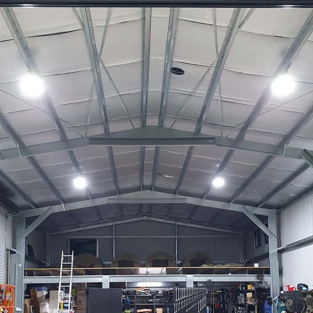 A large warehouse with a lot of lights hanging from the ceiling — KARM Electrical Services In Anna Bay, NSW