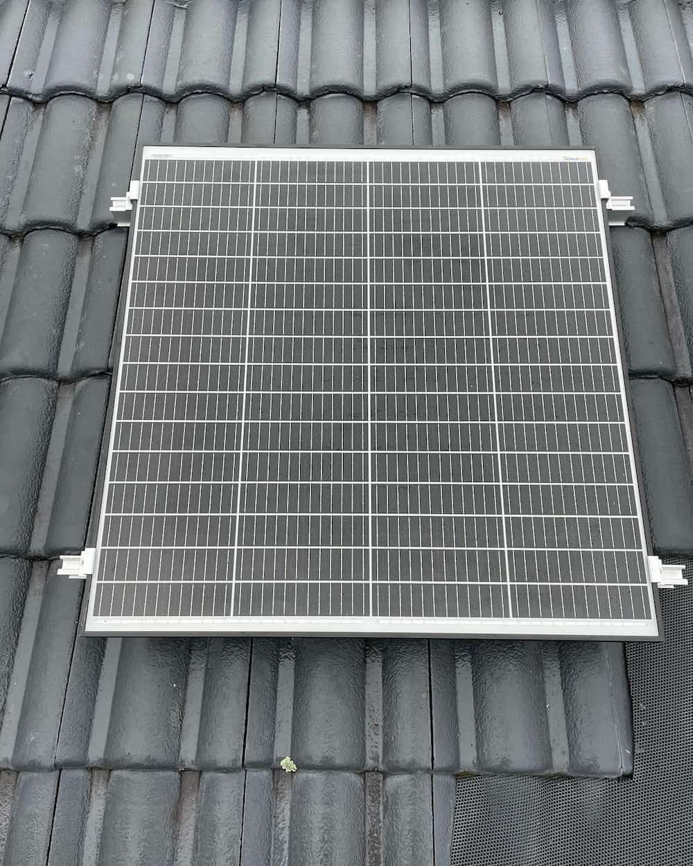 A Solar Panel Is Sitting On Top Of A Tiled Roof — KARM Electrical Services In Medowie, NSW