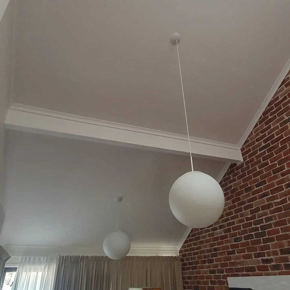 A Room With A Brick Wall And A White Ceiling With A Hanging Light — KARM Electrical Services In Fingal Bay, NSW