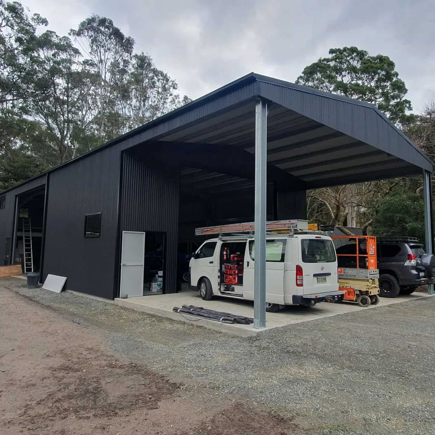 A White Service Van Is Parked Under A Canopy In Front Of A Black Building — KARM Electrical Services In Fingal Bay, NSW
