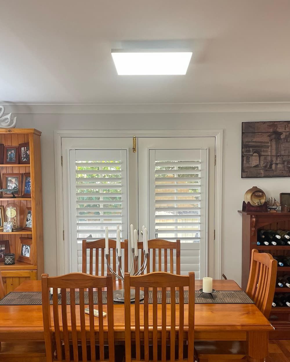 A Dining Room With A Table And Chairs With a Newly Installed Light— KARM Electrical Services In Nelson Bay, NSW