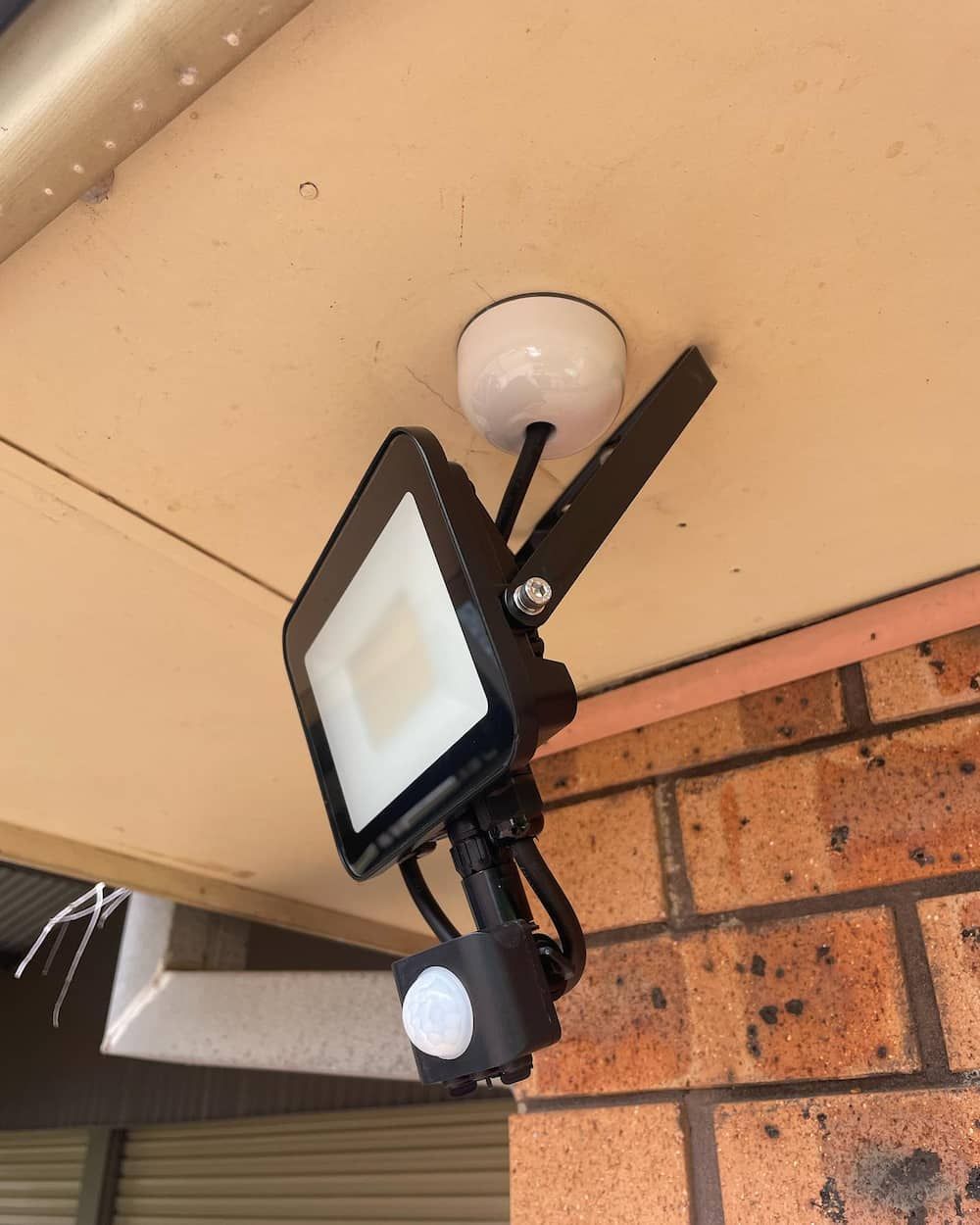 A Flood Light With A Motion Sensor Attached To It — KARM Electrical Services In Soldiers Point, NSW