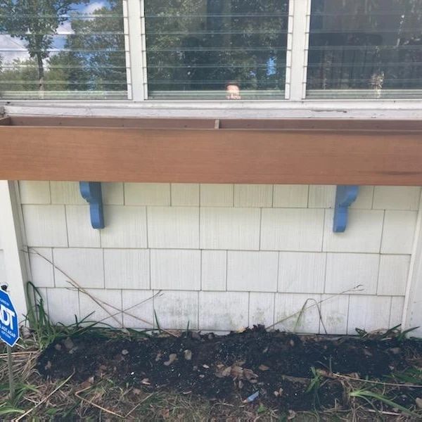 A window sill with a planter attached to it