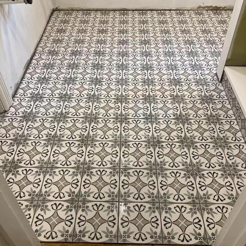 A tiled floor with a pattern on it in a room.