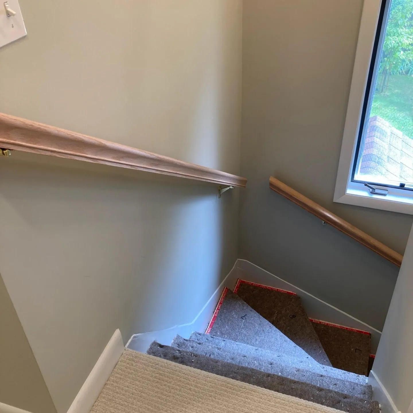 A staircase with a wooden railing and a window